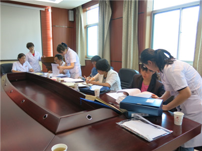 考核组认真查看患者病历及医保流程制度.JPG 考核组认真查看患者病历及医保流程制度.JPG